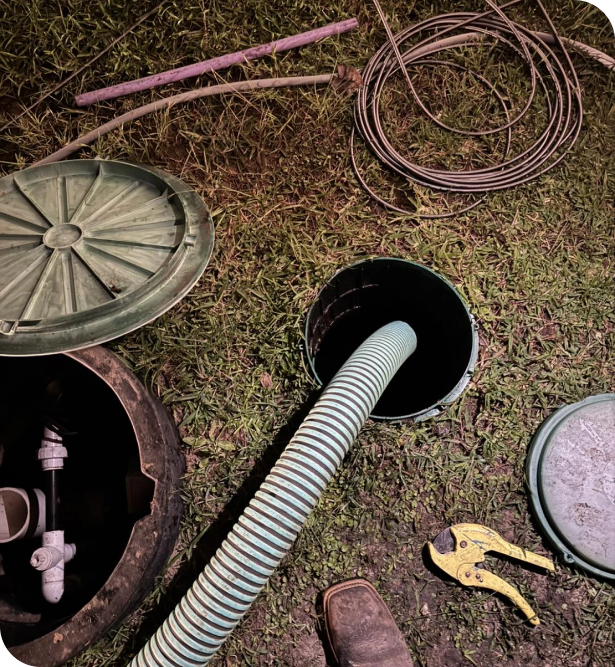 Open septic tank with hose inserted